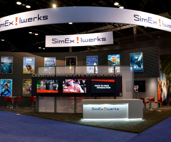 A view of a large tradeshow booth with many movie posters.