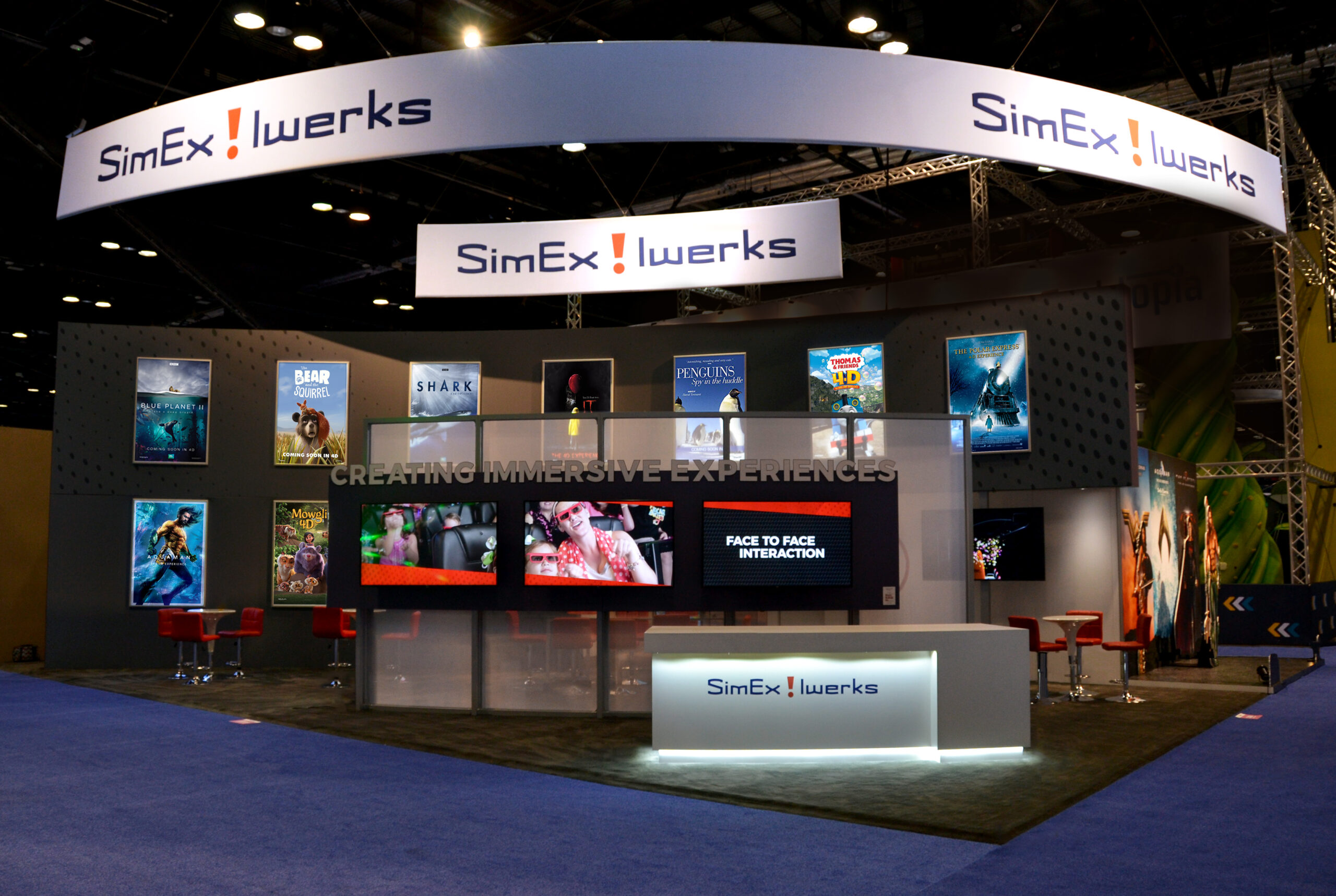 A view of a large tradeshow booth with many movie posters.